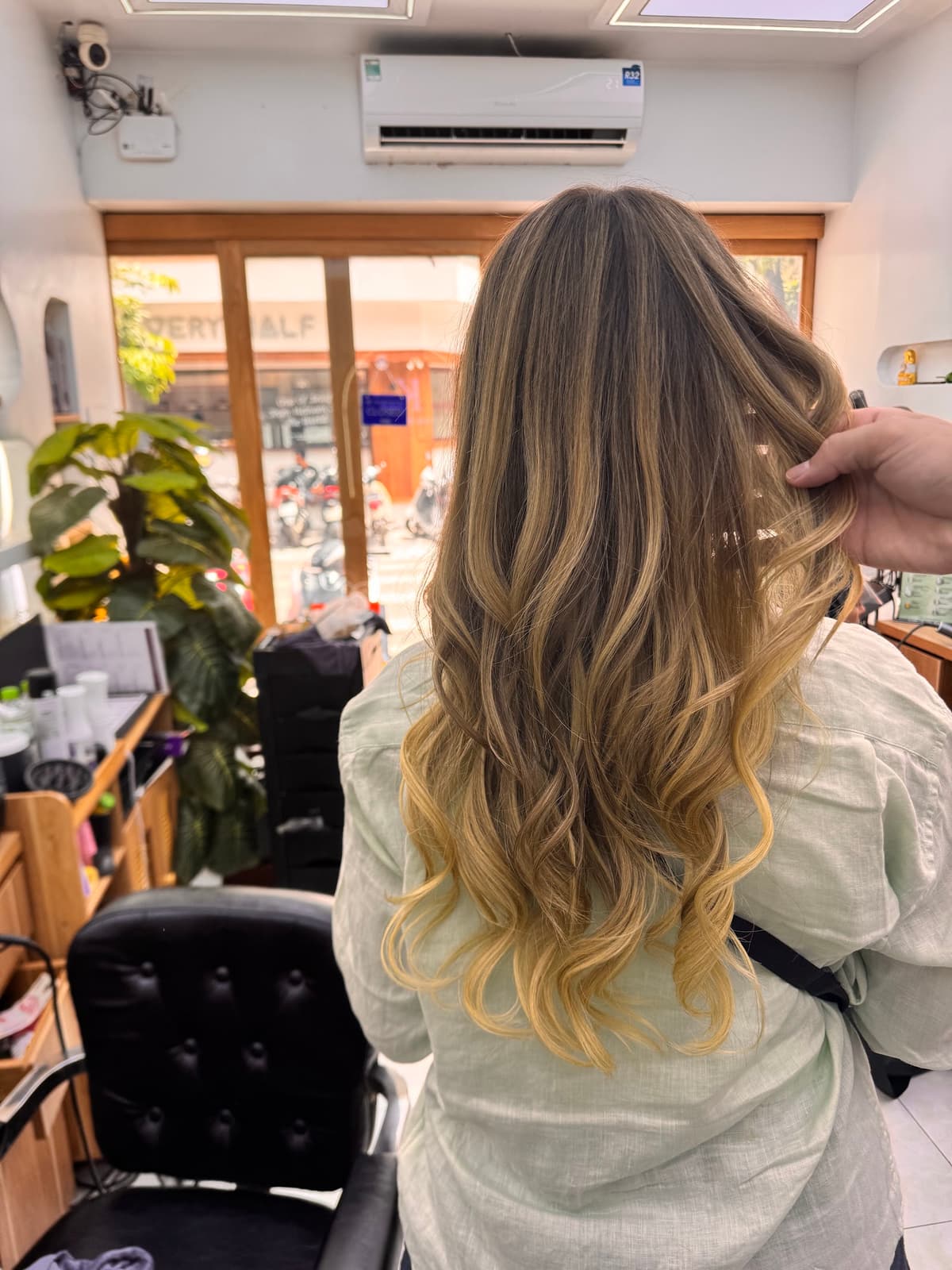 Stylist carefully curling hair with a professional curling iron